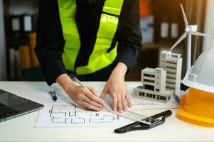 homme d'affaires travaillant à la main et ordinateur portable avec sur le projet architectural sur le chantier de construction au bureau au bureau photo