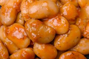 délicieux en conserve des haricots dans une tomate dans une rond céramique assiette photo