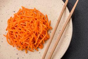 délicieux épicé carottes tranché et cuit dans coréen style sur une céramique assiette photo