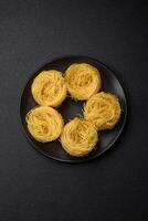 brut capellini Pâtes ou nouilles avec sel et épices photo