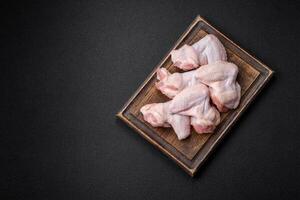 Frais brut poulet ailes avec sel et épices préparé pour cuisson photo