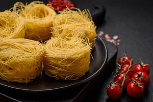 brut capellini Pâtes ou nouilles avec sel et épices photo