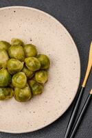 délicieux bouilli Bruxelles choux sur une céramique assiette sur une foncé béton Contexte photo