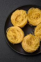 brut capellini Pâtes ou nouilles avec sel et épices photo