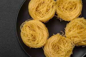 brut capellini Pâtes ou nouilles avec sel et épices photo