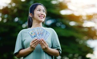 dollar dans le mains de un asiatique femme des économies, investissements, salaire, revenu, en espèces couler, bonheur et financier Succès et investissements. photo