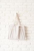 sac fourre-tout maquette tissu en coton blanc éco hipster sur mur de briques blanches photo