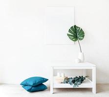 cadre d'affiche sur la table basse avec des décorations sur fond de mur blanc photo