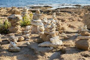 Les figures fabriqué de des pierres sur le rivages de le méditerranéen mer. photo