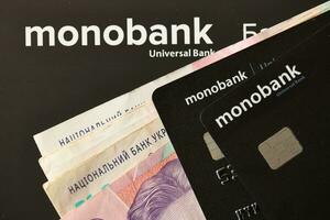 Kyiv, Ukraine - juillet 7, 2023 monobanque bancaire Plastique cartes avec argent sur table photo