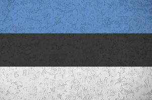drapeau de l'estonie représenté dans des couleurs de peinture vives sur un vieux mur de plâtrage en relief. bannière texturée sur fond rugueux photo