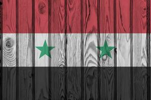 Syrie drapeau représenté dans brillant peindre couleurs sur vieux en bois mur. texturé bannière sur rugueux Contexte photo