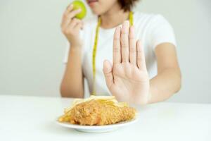 svelte femelle corps embrouiller français frites et frit poulet. femme dans restaurant atteint poids perte objectif pour en bonne santé vie, fou à propos minceur, mince taille, nutritionniste. régime, corps forme. photo