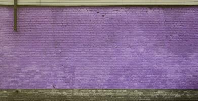 la texture du mur de briques de nombreuses rangées de briques peintes en violet photo