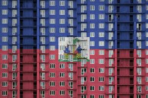 Haïti drapeau représenté dans peindre couleurs sur à plusieurs étages résidentielle bâtiment en dessous de construction. texturé bannière sur brique mur Contexte photo