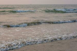 mousse de mer ou océan vagues contre le toile de fond de le réglage Soleil photo