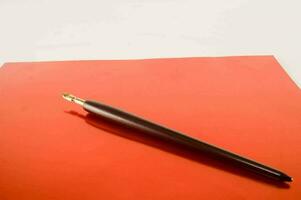 une stylo pose sur Haut de un Orange feuille photo