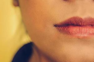 visage de beauté de la femme en appliquant du rouge à lèvres sur la bouche par des cosmétiques. photo