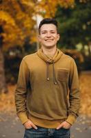 portrait de beau mec souriant dans le parc en automne photo