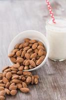 amandes renversées d'un bol blanc avec du lait d'amande photo