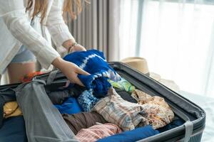 femme emballage valise sur lit pour une Nouveau périple emballage liste pour Voyage Planification en train de préparer vacances livre maintenant en voyageant transport photo