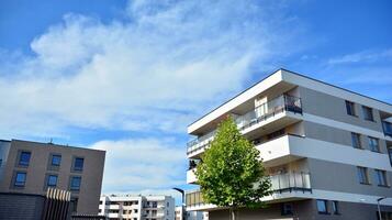 moderne appartement bâtiments sur une ensoleillé journée avec une bleu ciel. façade de une moderne appartement bâtiment. verre surface avec lumière du soleil. photo