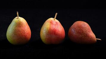 rouge et Jaune poires sur une noir Contexte. photo