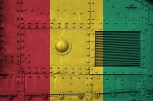 Guinée drapeau représenté sur côté partie de militaire blindé réservoir fermer. armée les forces conceptuel Contexte photo