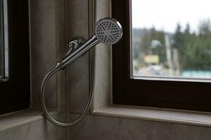 argenté douche dans moderne Hôtel salle de bains avec Naturel lumière photo