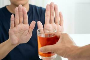 homme refuse dire non et éviter à boisson un de l'alcool whisky , arrêt main signe homme, alcoolisme traitement, de l'alcool dépendance, quitter biberonner, Arrêtez en buvant alcool. refuser verre alcool, mauvais pour la santé, rejeter photo