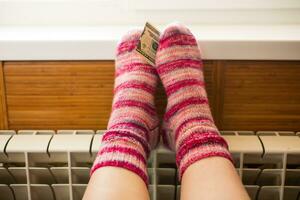 pieds dans chaud hiver chaussettes chaud en haut sur le radiateur. photo