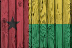 Guinée Bissau drapeau représenté dans brillant peindre couleurs sur vieux en bois mur. texturé bannière sur rugueux Contexte photo