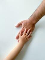 adulte et enfant tenir leur mains ensemble. les pères journée enfant donne main à adulte photo
