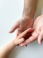 adulte et enfant tenir leur mains ensemble. les pères journée enfant donne main à adulte photo