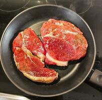 deux Haut aloyau du boeuf steaks dans une friture poêle. Accueil nourriture concept. photo
