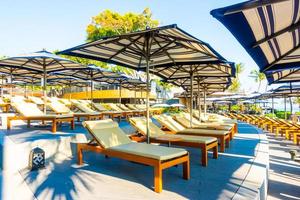 beau parasol et chaise de luxe autour de la piscine extérieure photo