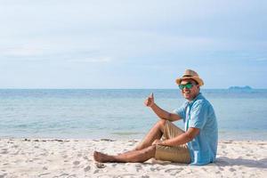 heureux jeune homme sur la plage tropicale photo