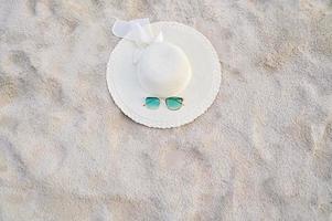 chapeaux et lunettes sont situés sur les plages de la mer bleue photo