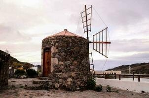 une Moulin à vent sur le côté de une pierre bâtiment photo