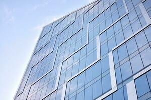 verre bâtiment avec transparent façade de le bâtiment et bleu ciel. de construction verre mur reflétant bleu ciel. abstrait moderne architecture fragment. contemporain architectural Contexte. photo