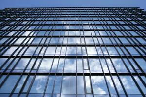 verre bâtiment avec transparent façade de le bâtiment et bleu ciel. de construction verre mur reflétant bleu ciel. abstrait moderne architecture fragment. contemporain architectural Contexte. photo