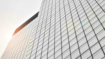 verre moderne bâtiment avec bleu ciel Contexte. vue et architecture détails. Urbain abstrait - les fenêtres de verre Bureau bâtiment dans lumière du soleil journée. noir et blanche. photo