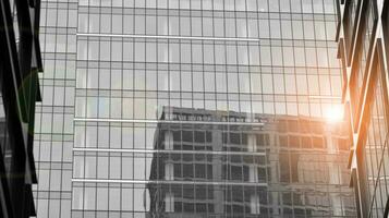 verre moderne bâtiment avec bleu ciel Contexte. vue et architecture détails. Urbain abstrait - les fenêtres de verre Bureau bâtiment dans lumière du soleil journée. noir et blanche. photo