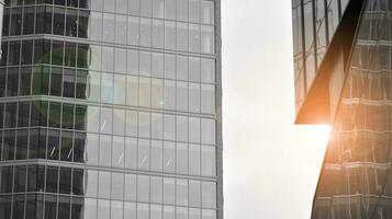 verre moderne bâtiment avec bleu ciel Contexte. vue et architecture détails. Urbain abstrait - les fenêtres de verre Bureau bâtiment dans lumière du soleil journée. noir et blanche. photo