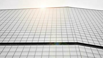 verre moderne bâtiment avec bleu ciel Contexte. vue et architecture détails. Urbain abstrait - les fenêtres de verre Bureau bâtiment dans lumière du soleil journée. noir et blanche. photo