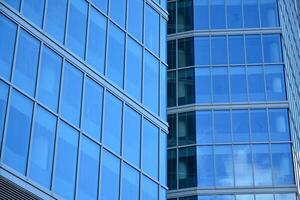 moderne Bureau bâtiment avec verre façade sur une clair ciel Contexte. transparent verre mur de Bureau bâtiment. photo