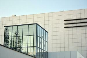 moderne Bureau bâtiment avec verre façade sur une clair ciel Contexte. transparent verre mur de Bureau bâtiment. photo