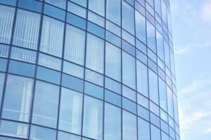 moderne Bureau bâtiment avec verre façade sur une clair ciel Contexte. transparent verre mur de Bureau bâtiment. photo