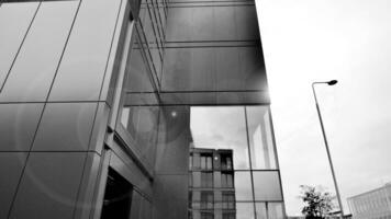 une vue à une tout droit façade de une moderne bâtiment avec une foncé gris façade. foncé gris métallique panneau façade. moderne architectural détails. noir et blanche. photo