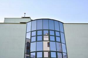 moderne Bureau bâtiment avec verre façade sur une clair ciel Contexte. transparent verre mur de Bureau bâtiment. photo